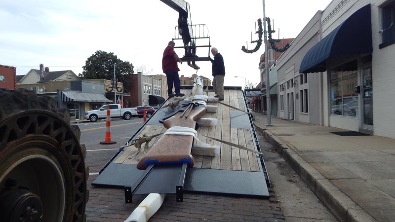 The gun arriving on a flatbed truck in downtown Rogers